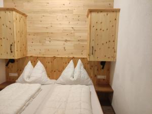 a bed with white pillows in a room at Zeffereralm in Forstau