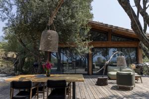 a patio with a wooden table and chairs at Résidence Licciola in Propriano
