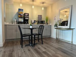 a kitchen with a table and two chairs and a mirror at Quarters Inn & Suites in Antioch