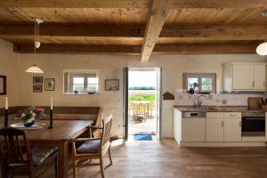 NeuenkirchenにあるFerienhaus Remise In Neuenkirchenのテーブルと椅子のあるキッチンとダイニングルーム