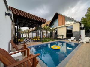 een zwembad met een vlot in het midden van een huis bij Qafqaz Retro Bungalow HOT POOL in Gabala