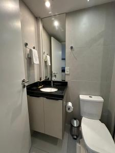 ein Badezimmer mit Toilette, Waschbecken und Spiegel in der Unterkunft Estudio Aurea Bauten 210 in Tambaú