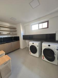 eine Waschküche mit zwei Waschmaschinen und einem Fenster in der Unterkunft Estudio Aurea Bauten 210 in Tambaú + 24 Fotos