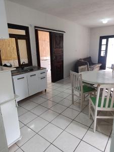 a kitchen and living room with a table and chairs at Casa em Itapema in Itapema