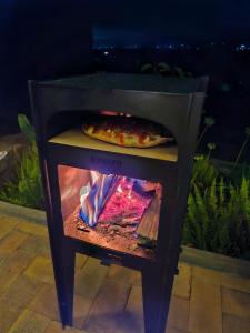NemocónにあるVive Rela Tiny Housesのピザは屋外のオーブンで調理中
