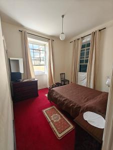 a bedroom with a bed and a television and a window at Mirasol Guesthouse in Funchal