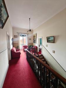 a living room with a red carpet and a staircase at Mirasol Guesthouse in Funchal