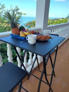 a blue table with a plate of food on a balcony at T2 des Tortues in Bouillante