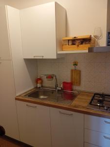 eine Küche mit weißen Schränken und einer Spüle in der Unterkunft La Casina di Lalu' in Meleto