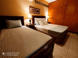 a bedroom with two beds and two lamps in it at Departamentos de Altura in Tarija