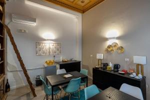a dining room with a table and blue chairs at Fourooms Bari - Sparano in Bari