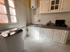 a kitchen with white cabinets and a sink at Residence Diar Kisane in Marrakech