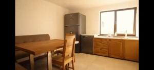 a small kitchen with a table and a refrigerator at Cabana Stil in Mărişel +14 photos