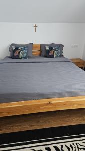 a bed with a wooden frame and pillows on it at Cabana Stil in Mărişel