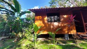 a small wooden cabin with a window in a forest at Aura Bungalow in Tamarindo +12 photos