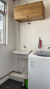a white bathroom with a sink and a tub at Apto aconchegante, central, prox ao carrefour in Santa Maria