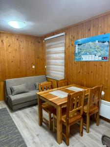 a dining room with a table and a couch at Ski kuca Elbrus in Jahorina