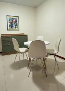 a dining room with three chairs and a table at Apto aconchegante, central, prox ao carrefour in Santa Maria