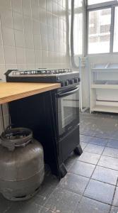 a kitchen with a stove and a counter top at Apto aconchegante, central, prox ao carrefour in Santa Maria +3 photos
