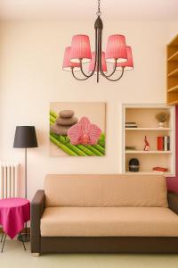 a living room with a couch and a pink chandelier at REALE COLOSSEO TREVI HOME - private garden in Rome