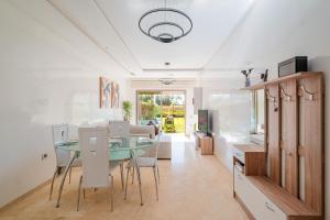 une cuisine et une salle à manger avec une table et des chaises en verre dans l'établissement Appartement de prestige au golf, à Marrakech