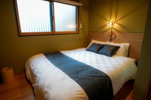 a bedroom with a large bed with blue pillows at Tabiudo Stay Miyajima 01-02 - Vacation STAY 20514 in Fukae