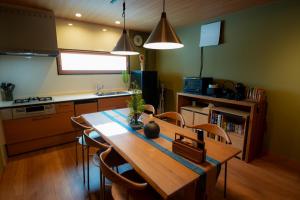 a kitchen with a wooden table and chairs at Tabiudo Stay Miyajima 01-02 - Vacation STAY 20514 in Fukae +11 photos