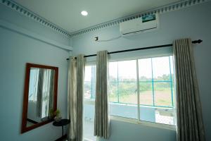 a room with a large window and a mirror at Best Inn in Jaffna