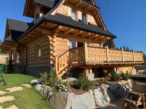 a log cabin with a deck and a porch at Ostoja Spokoju in Kościelisko