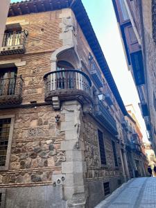 a stone building with a balcony on the side of it at Hotel Boutique Casón De Los López in Toledo