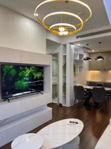 a living room with a large flat screen tv on a wall at Hommit - Căn hộ View Bể Bơi 3 Phòng ngủ, 2 vệ sinh - Tòa Masteri A, Vinhomes Smart City in Phú Thú