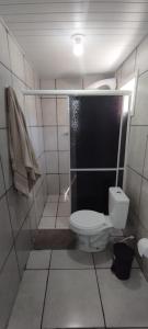 a small bathroom with a toilet and a shower at Pousada Gaúcha Caibi 