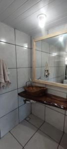 a bathroom with a wooden sink and a mirror at Pousada Gaúcha Caibi 