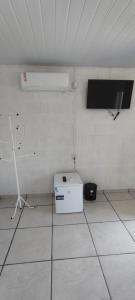 a white room with a tv and a refrigerator at Pousada Gaúcha Caibi 