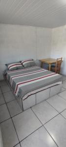 a large bed in a room with a table at Pousada Gaúcha Caibi 