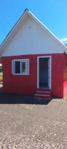 a red and white house with a red door at Pousada Gaúcha Caibi 