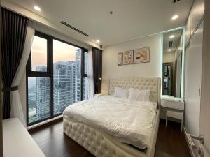 a bedroom with a large white bed with a large window at Hommit - Căn hộ View Bể Bơi 3 Phòng ngủ, 2 vệ sinh - Tòa Masteri A, Vinhomes Smart City in Phú Thú +21 photos