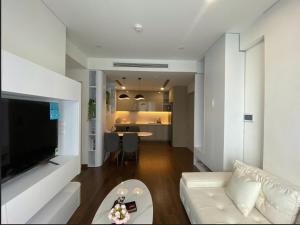 a living room with a white couch and a table at Hommit - Căn hộ View Bể Bơi 3 Phòng ngủ, 2 vệ sinh - Tòa Masteri A, Vinhomes Smart City in Phú Thú