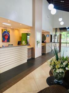 a lobby with a counter with a vase of flowers at Ceta Ecotel in Macapá +24 photos
