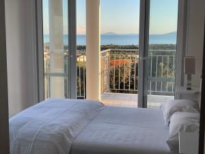 ein Schlafzimmer mit einem weißen Bett und einem großen Fenster in der Unterkunft Villa Evangelia in Karavádhos