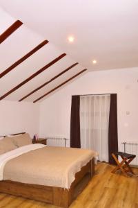 a bedroom with a bed and a wooden floor at Chez Vila in Prizren