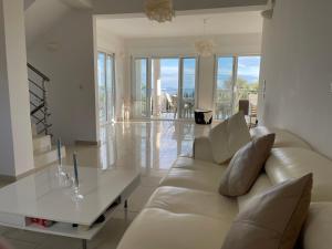 ein Wohnzimmer mit einer weißen Couch und einem Glastisch in der Unterkunft Villa Evangelia in Karavádhos