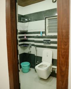 een badkamer met een toilet en een blauw bidet bij The Metro Nest in Guwahati