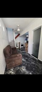 a living room with a brown couch in a room at Marea Home in Arraial do Cabo
