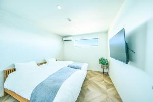 ein Schlafzimmer mit einem Bett und einem Flachbildfernseher in der Unterkunft Sunny Life Villa Awaji - Vacation STAY 63073v in Akashi