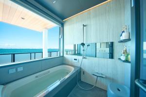 ein Badezimmer mit Badewanne und großem Fenster in der Unterkunft Sunny Life Villa Awaji - Vacation STAY 63073v in Akashi + 38 Fotos