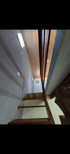 una mansarda con scale e soffitto in legno di Marea Home ad Arraial do Cabo Altre 3 foto