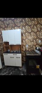 a kitchen with white cabinets and a stove at Marea Home in Arraial do Cabo
