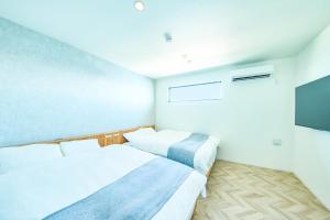 ein Schlafzimmer mit zwei Betten und einem Flachbildfernseher in der Unterkunft Sunny Life Villa Awaji - Vacation STAY 63073v in Akashi