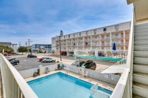a pool in front of a hotel with a parking lot at Wildwood Condo with Community Pool Walk to Beach! in Wildwood